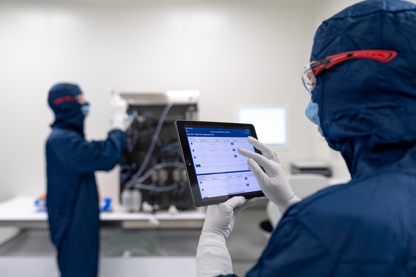 Worker on a factory floor using a tablet to update production status